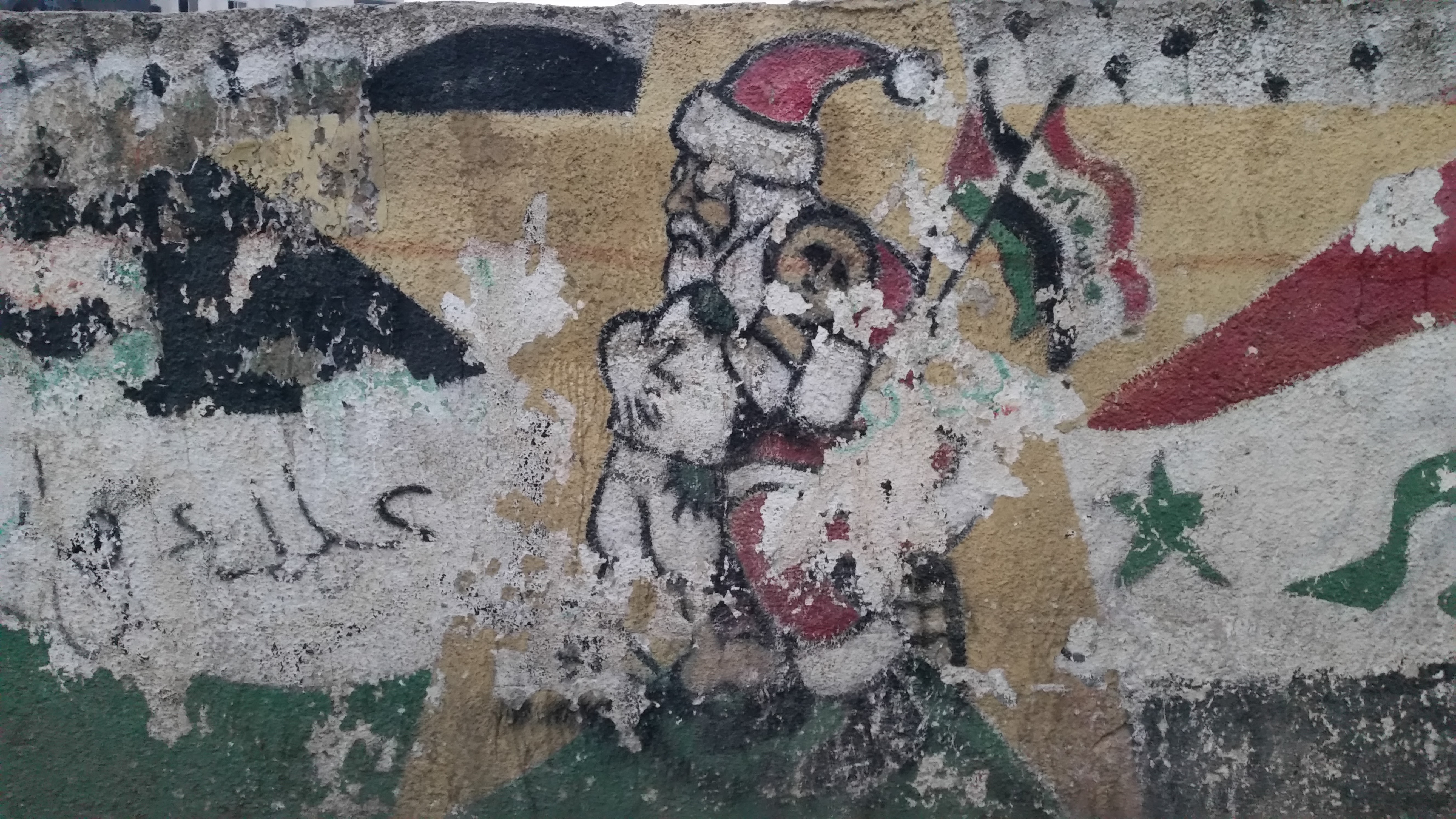 Ramallah belvárosában, a télapó vigyáz egy palesztin kisfiúra egy festményen.