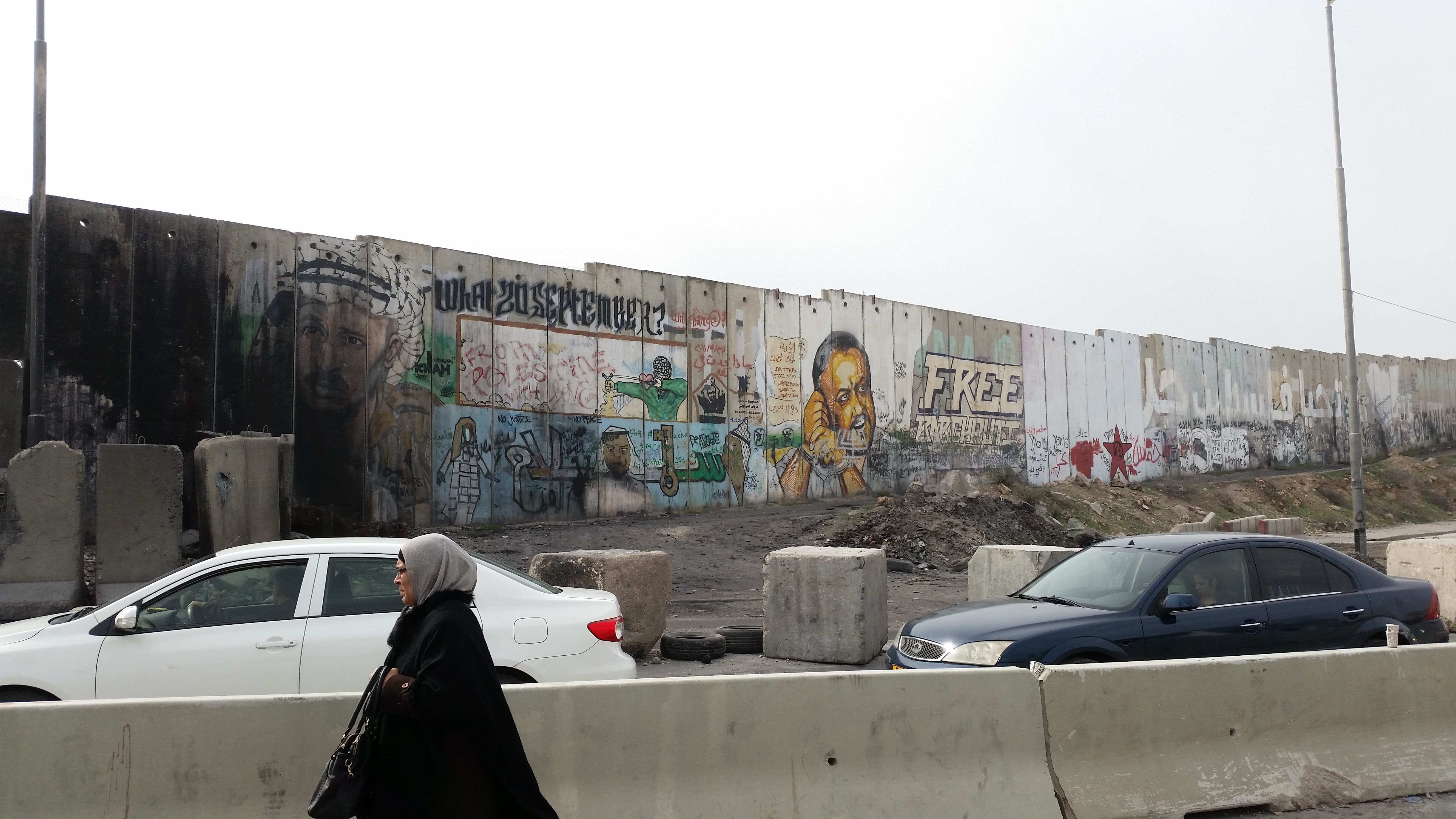 Fal Kalandiánál, a Ramallah és Jeruzsálem közötti fő ellenőrző pontnál. A legtöbb helyen a fal palesztin oldalán képekkel és festett feliratokkal üzennek a palesztinok.