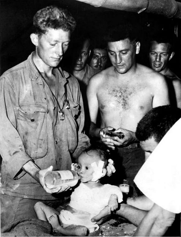 1944_november_amerikai_katonak_etetnek_egy_filippino_kisgyereket_akit_a_visszavonulo_japanok_bajonettel_tobbszor_is_megszurtak.jpg