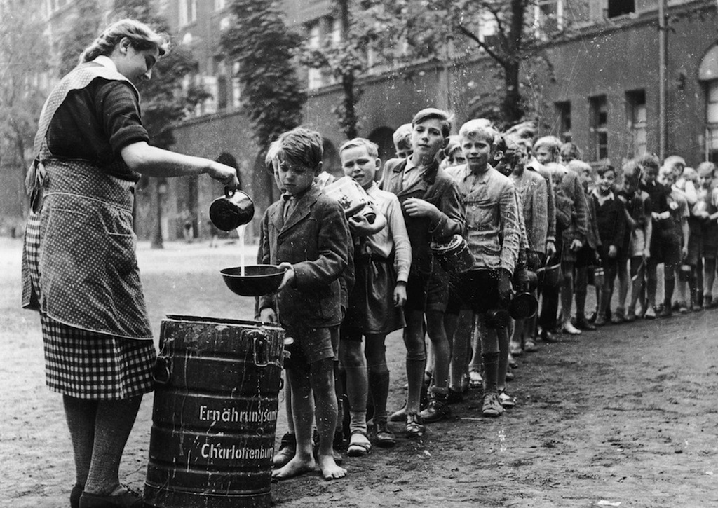 1945_gyerekek_varnak_az_ingyenebedre_egy_berlin-charlottenburgi_iskolaban_ami_vizes_tejben_fott_liszt.jpeg