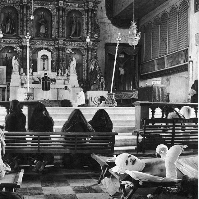 1944_badly_burned_u_s_officer_lies_on_his_hospital_stretcher_in_a_church_in_leyte_while_there_is_a_mass_going_on_the_church_worked_as_a_temporary_hospital_philippines.jpg