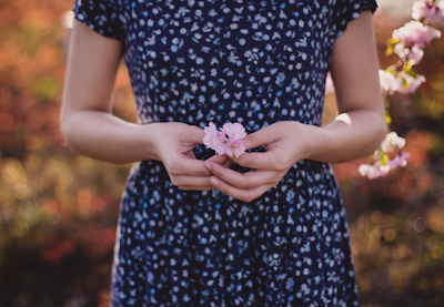 canva_women_in_blue_and_white_floral_dress_with_pink_flower_on_hand.jpg