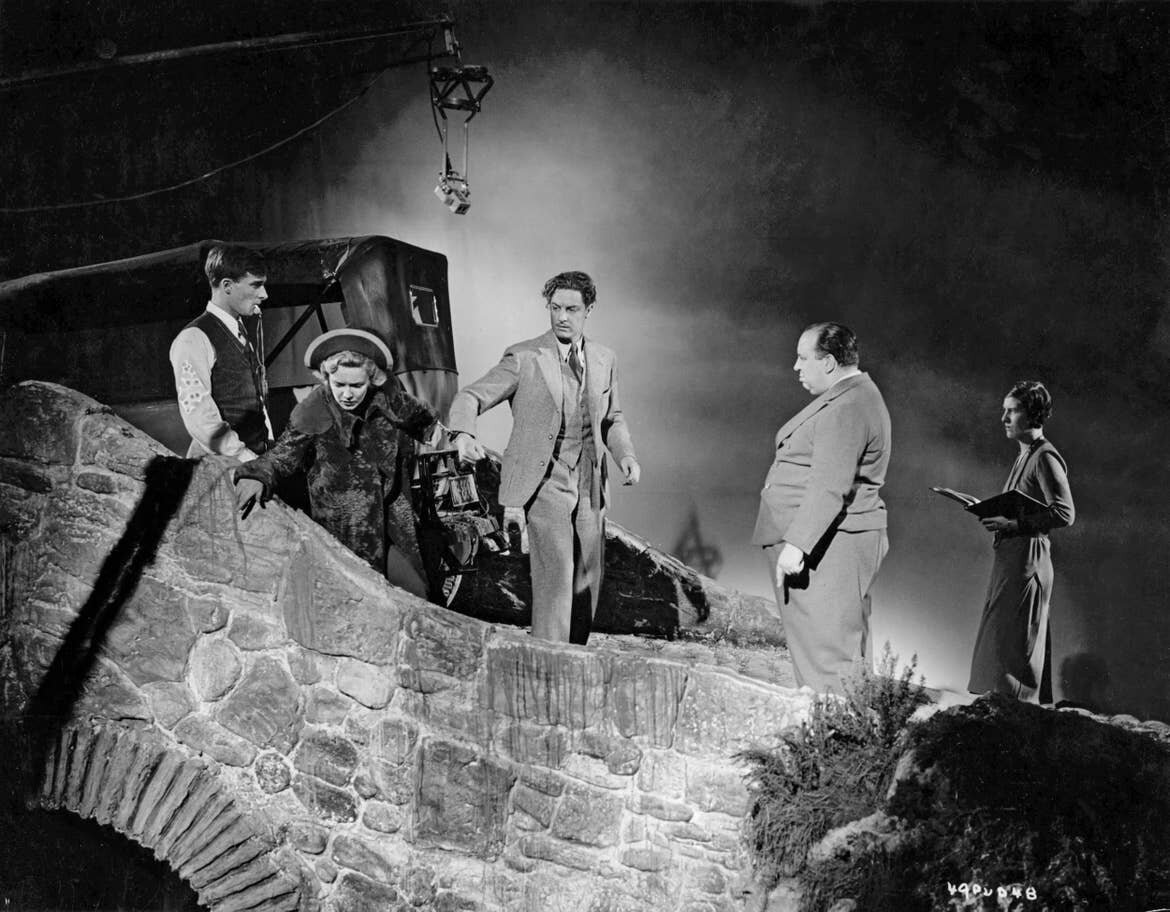 the-39-steps-1935-alfred-hitchcock-second-right-directing-the-handcuffed-madeleine-carroll-and-robert-donat-on-the-first-day-of-filming.jpg
