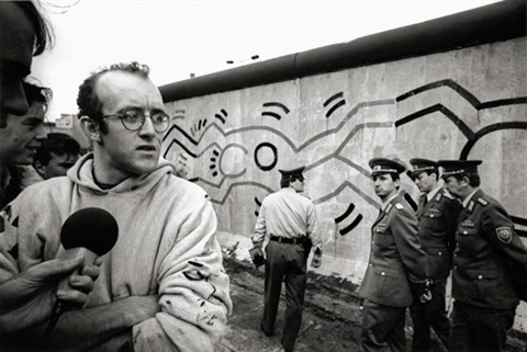 Haring a Berlini fal előtt, háttérben a munkája