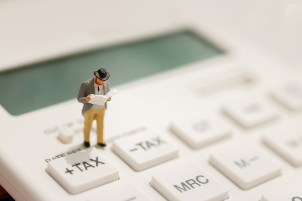 miniature-businessman-stand-reading-tax-button-calculator.jpg