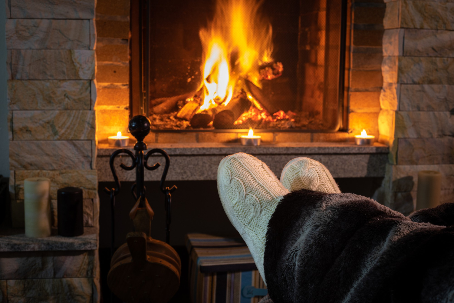 woman-s-feet-by-fireplace-lit-comfort-your-home.jpg