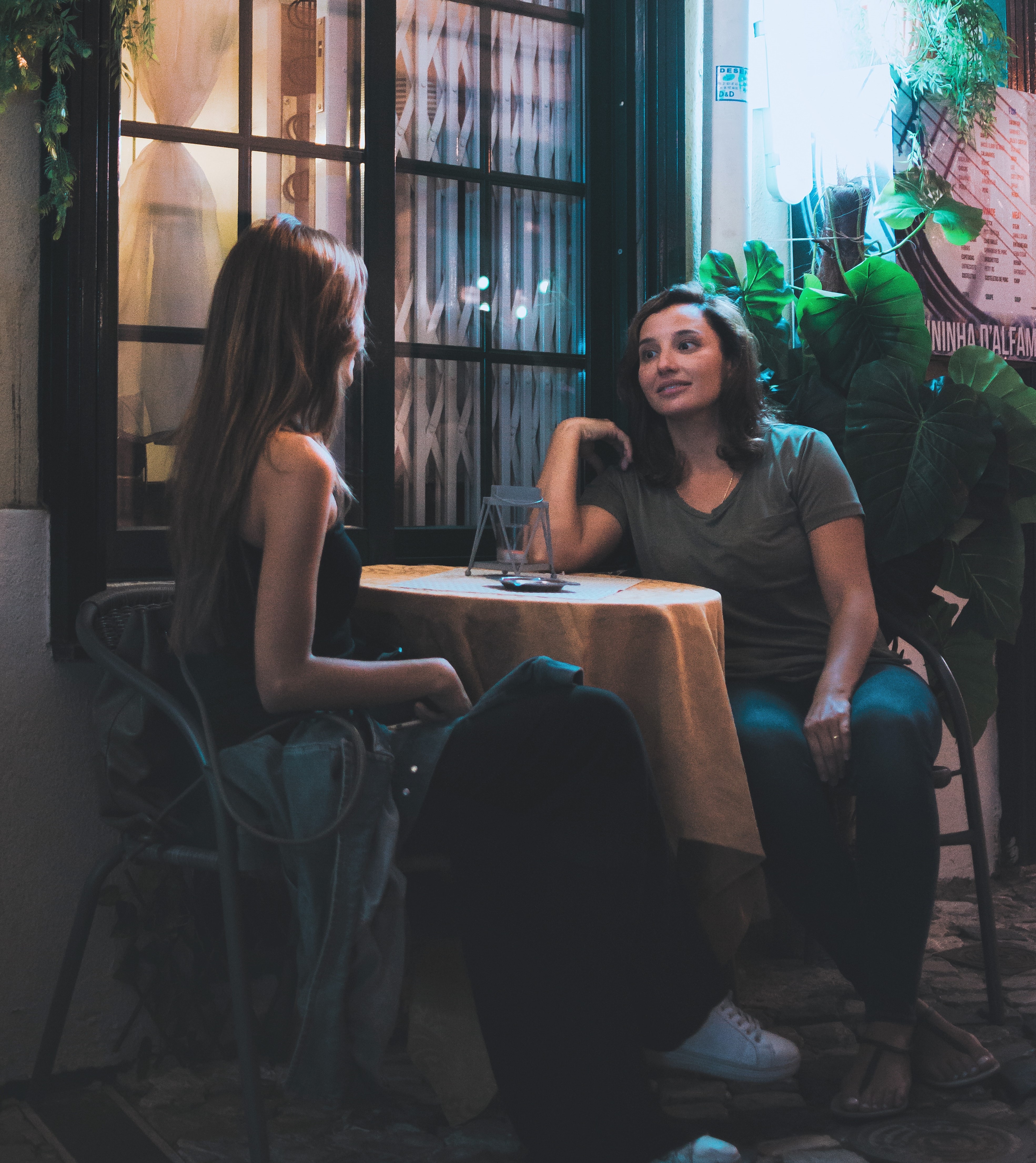 two-women-sitting-and-chatting-near-table-1545499.jpg