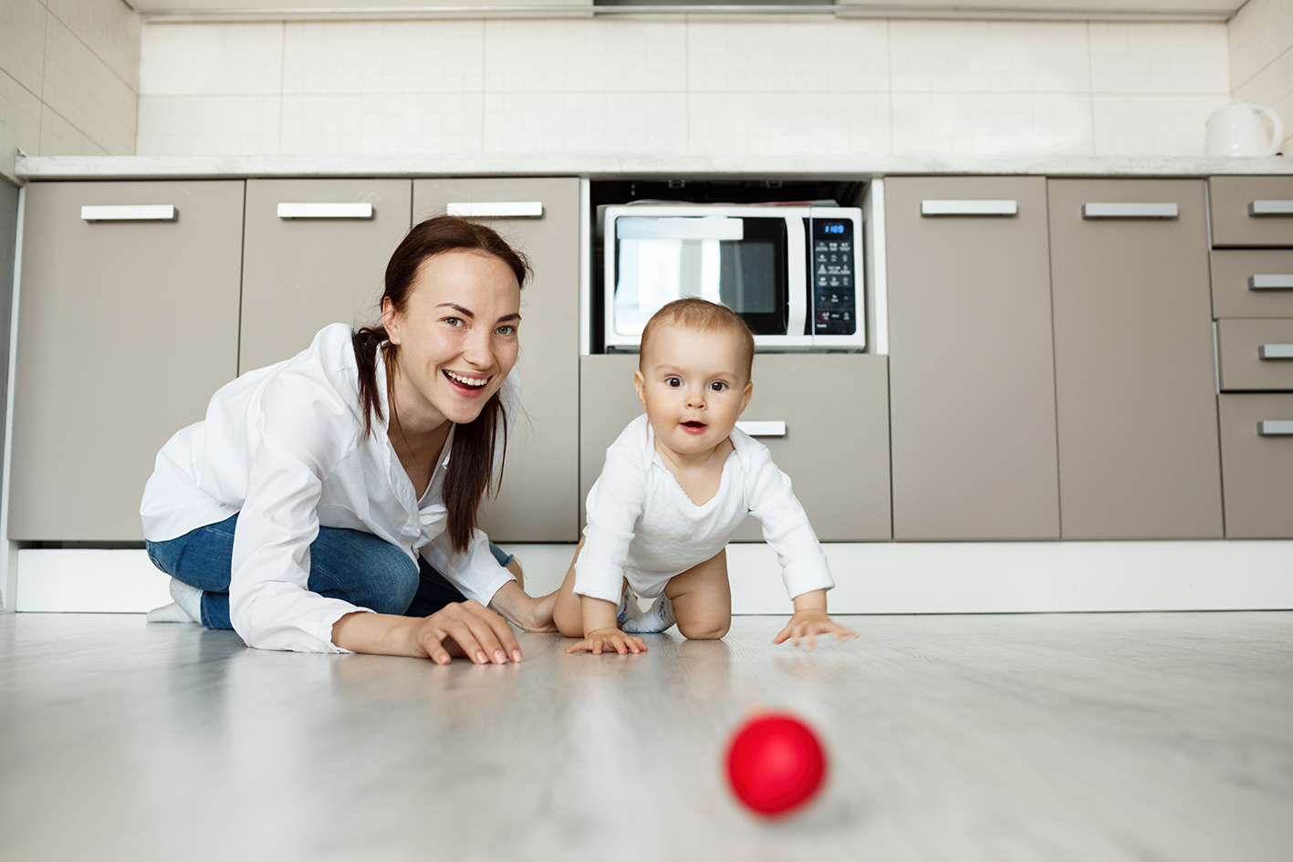 mother-smiling-as-baby-crawling-floor-get-ball.jpg