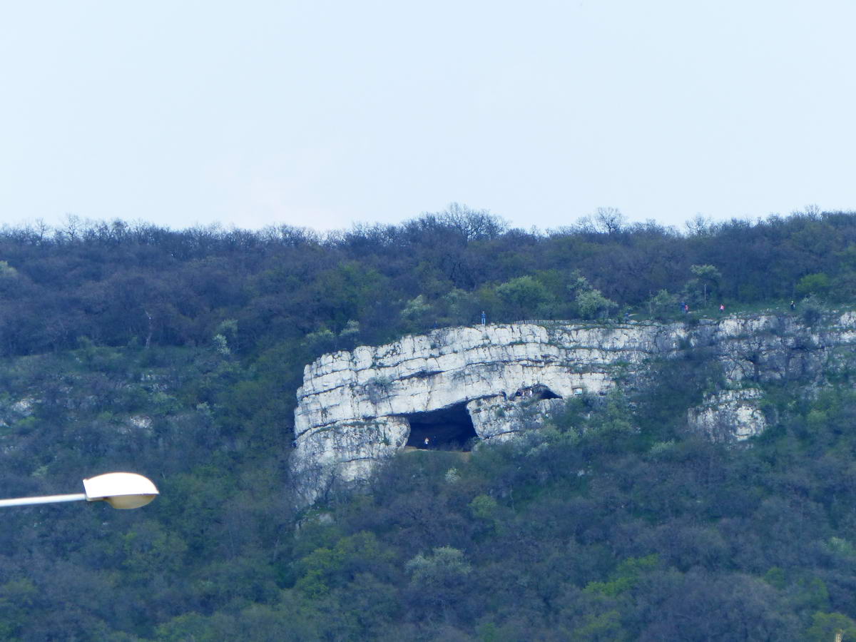 Már Tatabánya belvárosából is jól látható az Öreg-hegy sziklás oldalában nyíló Szelim-barlang. A kép a Fő térről készült. Látható, hogy valaki áll fenn a barlang szájában.