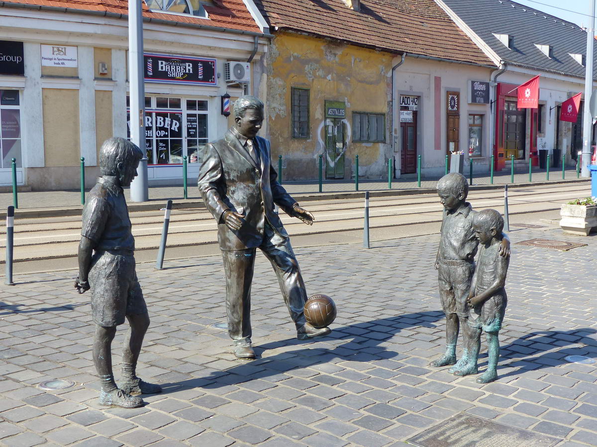 Ez nem Kolodko Mihály szobra, de éppen útba esett: Puskás Öcsi dekázgat a gyerekek előtt