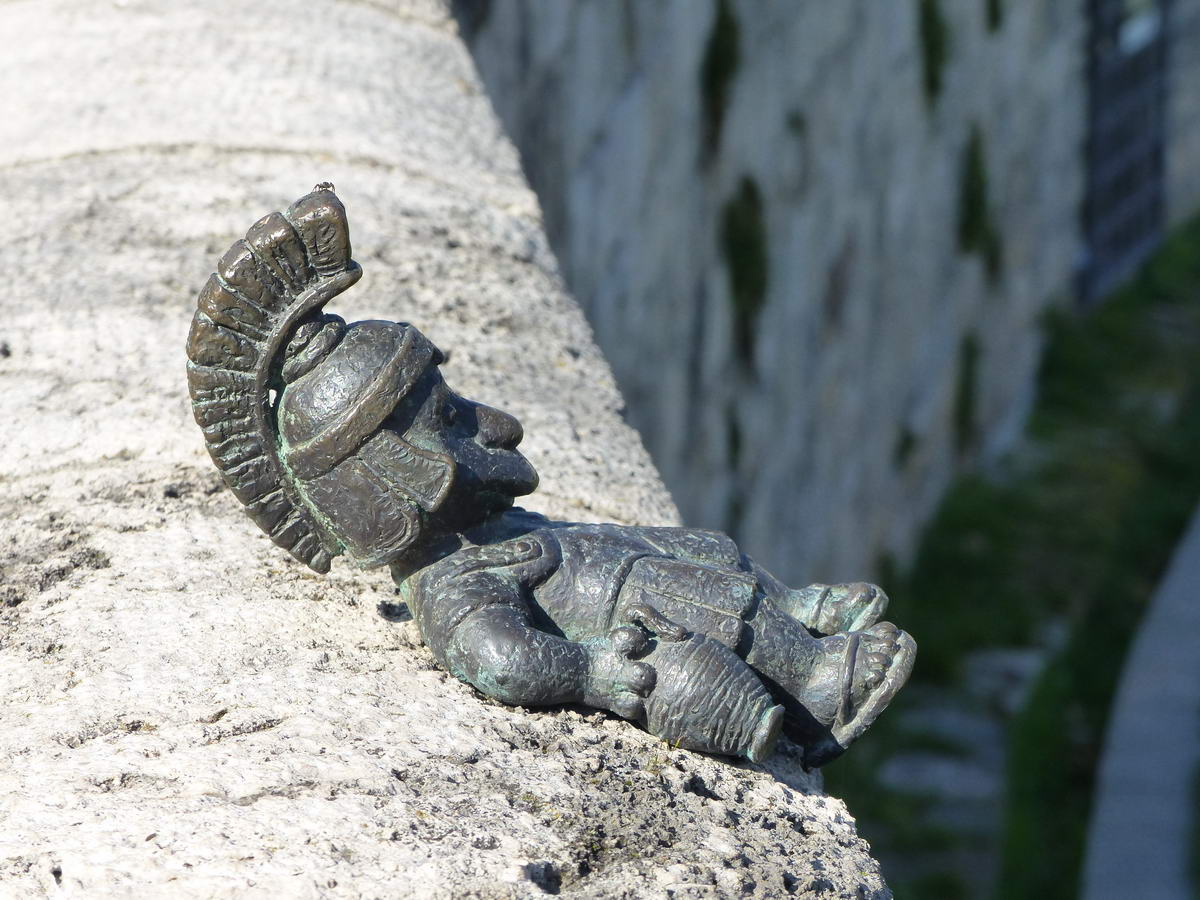 A mai utolsó miniszobor: ittas római katona fekszik a Nagyszombat utcai amfiteátrum kőmellvédjén