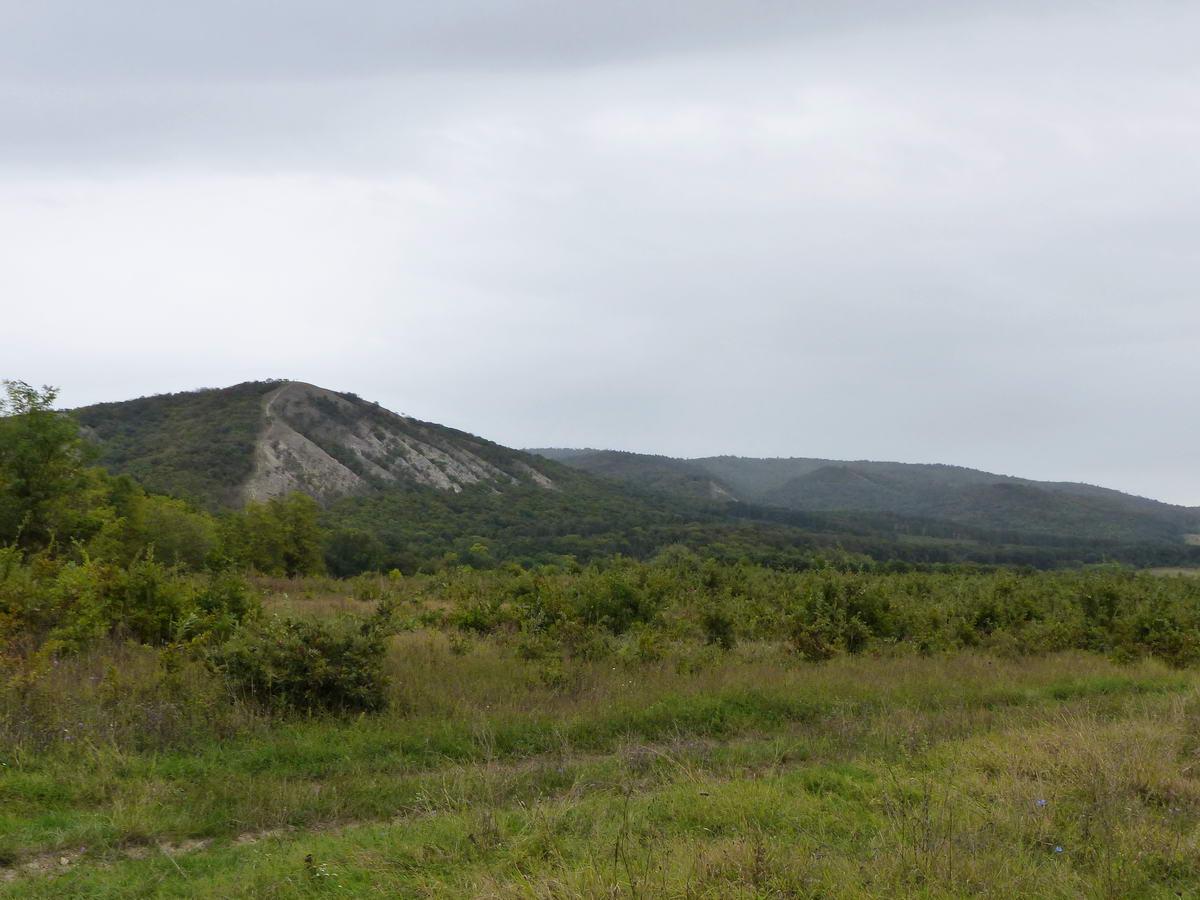 Visszatekintés az esőbe burkolózó gerincre és a sziklás oldalú Meszes-hegyre