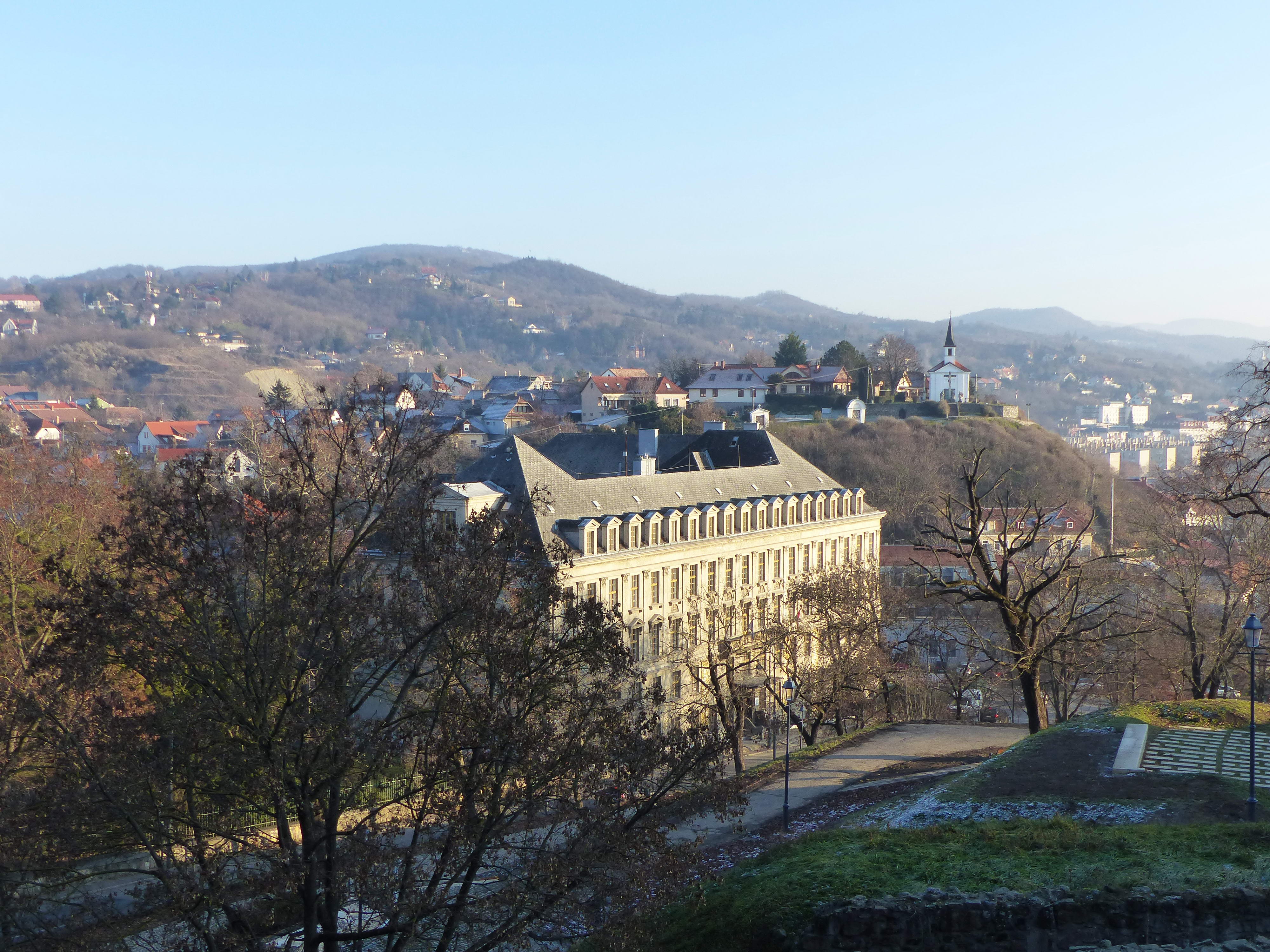 Visszatekintés a Bazilika mellől a Szent Tamás kápolnára és a távolban balra álló Vaskapu-hegyre. Az előtérben a Pázmány Péter Katolikus Egyetem Vitéz János Karának palotája áll.