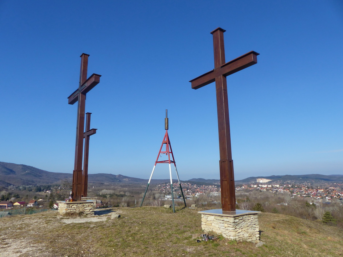 A csúcson állnak a fakeresztek. A geodéziai alappont háromlábú fémállványa kicsit ront az összképen.