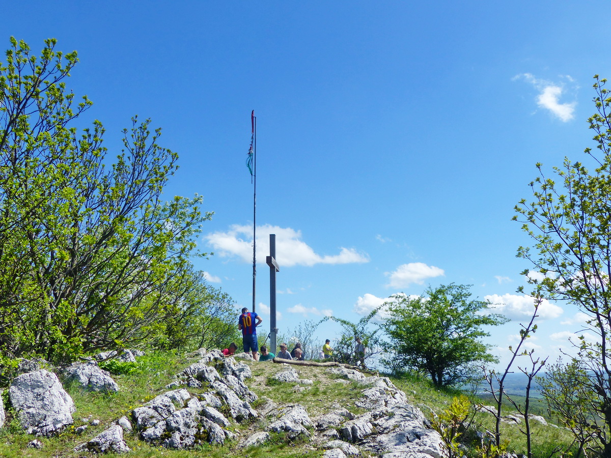 Tépett zászló és fakereszt áll a csúcson