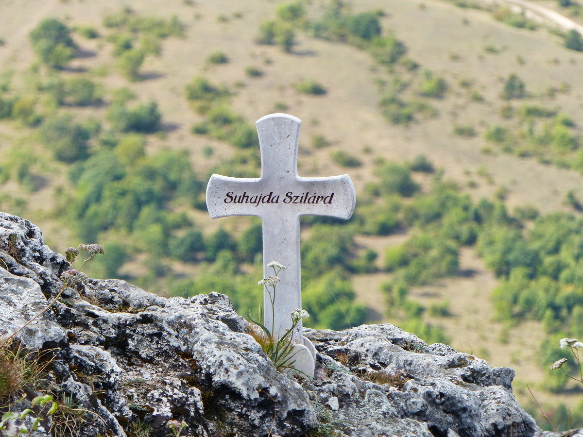 Pici kőkereszt áll a sziklákon Suhajda Szilárd emlékére