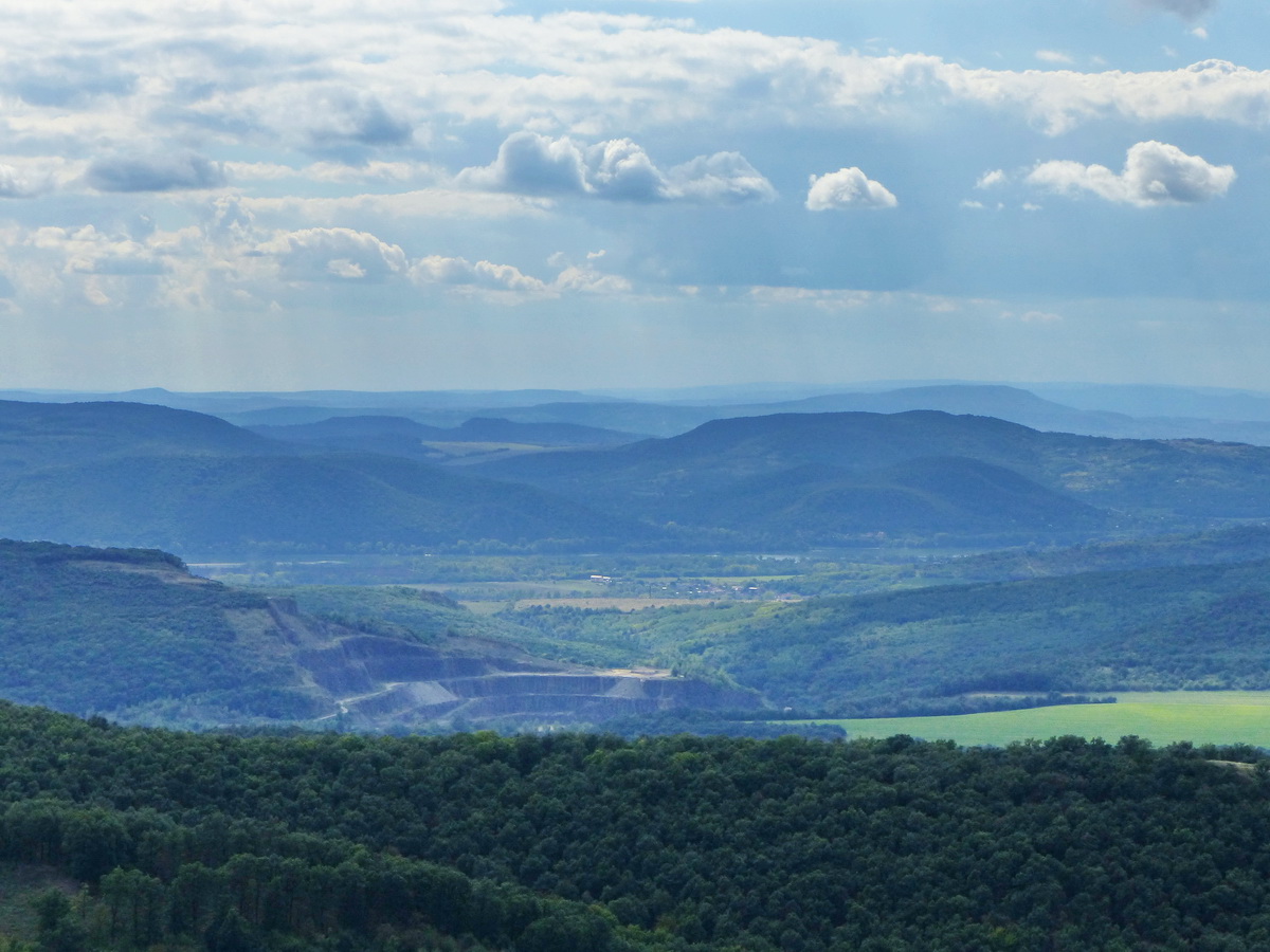 Az előtérben a Csák-hegy lebányászott oldala, mögötte a Duna, a háttérben a Maróti-hegyek