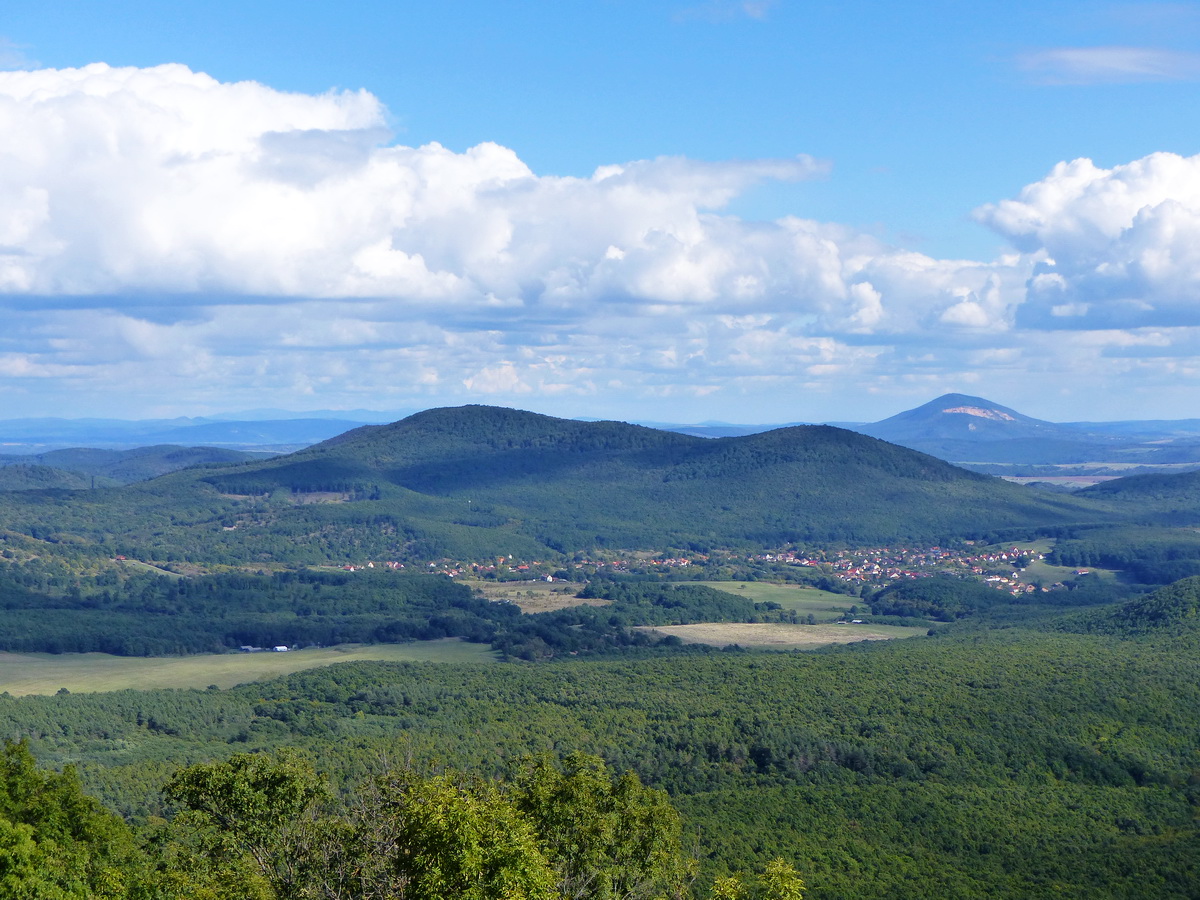 Kilátás Kóspallagra, a mögötte álló Fekete-hegyre és a távoli Naszályra. Balra a messzeségben a Mátra is feltűnik.
