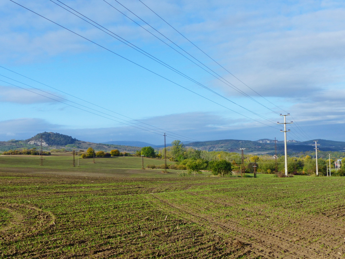 Balra a Hegyes-kő, középen a messzeségben a Nagy-Gerecse, tőle jobbra a Kőszikla, majd a Bajóti Öreg-kő kétpúpú háta következik