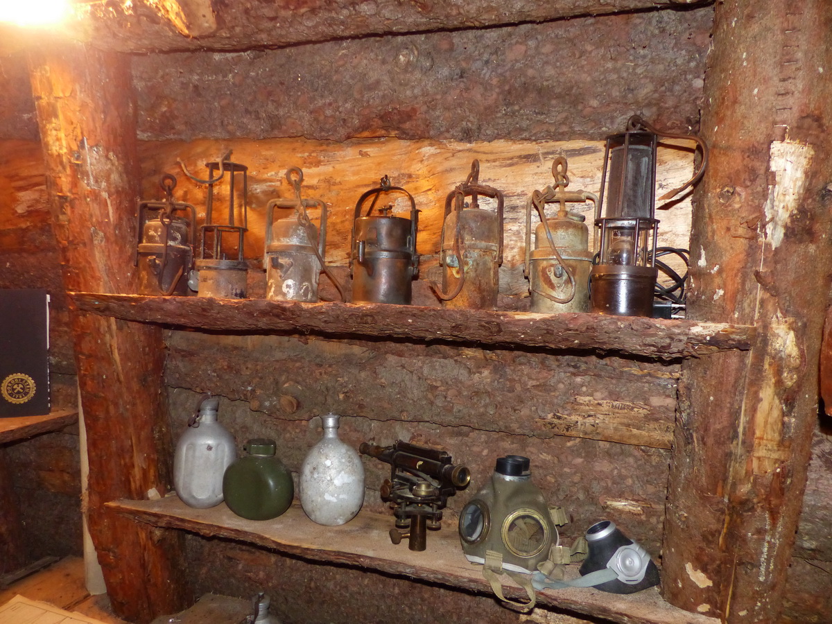 Bányászlámpák, kulacsok, gázálarcok és egy régi teodolit az emlékszoba egyik polcán