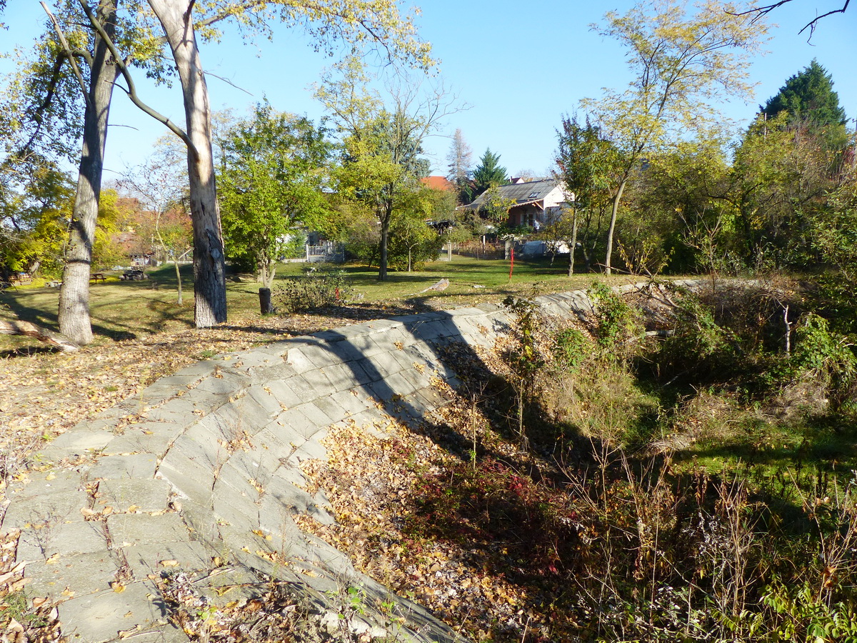 Félbehagyott tavacska kikövezett partja a község peremén