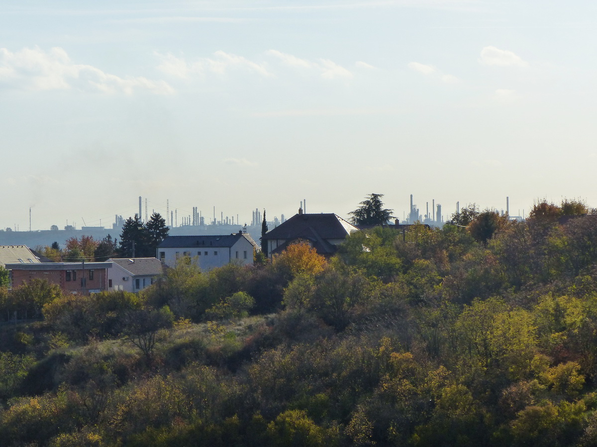 A domb felett feltűnnek az olajfinomító lepárlótornyai