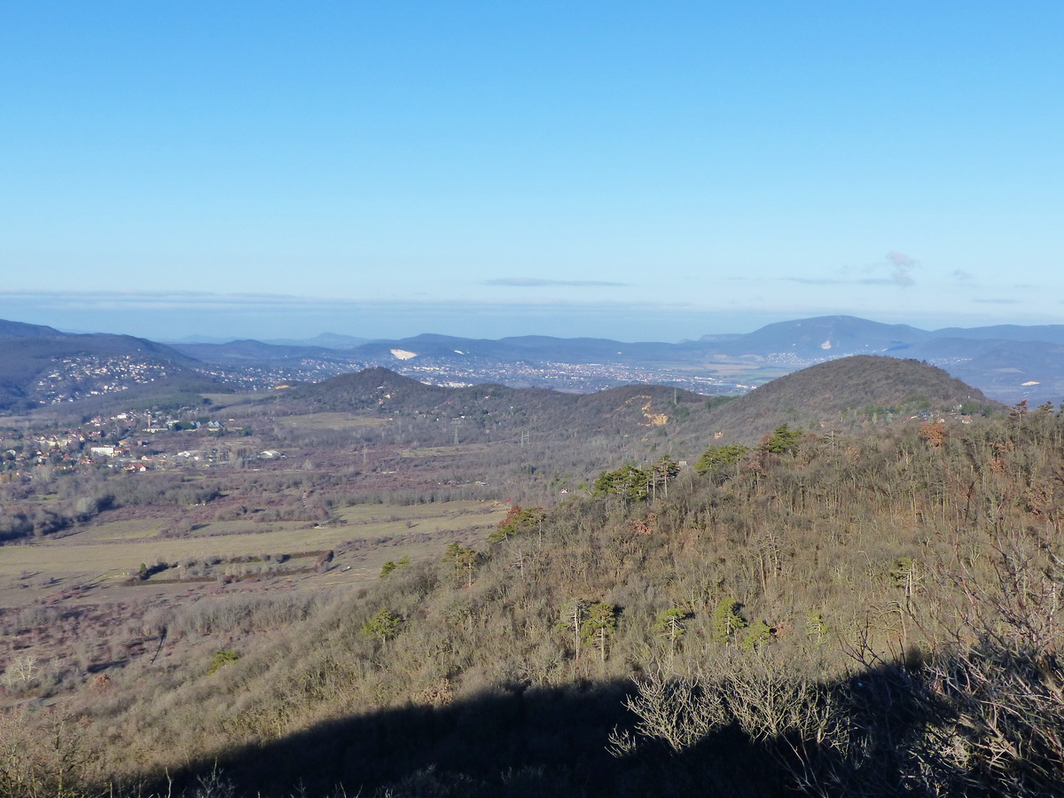 Előtérben a Budai-hegység északi karéja a Kálvária-hegytől (balra) a Csúcs-hegyig (jobbra), a háttérben jól látszanak a Gerecse és a Pilis csúcsai