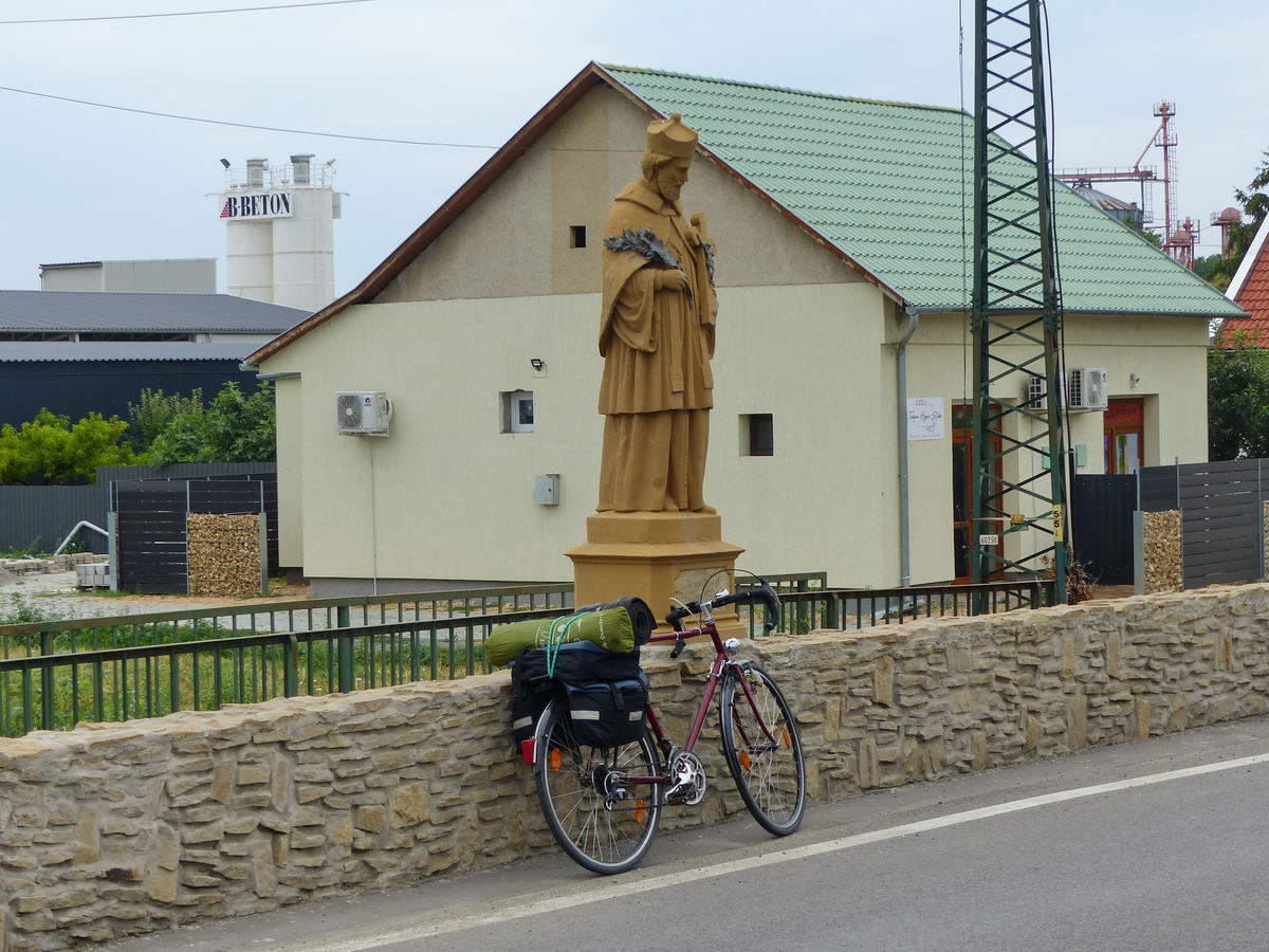 Nepomuki Szent János szobra alatt várakozik a bringa a továbbindulásra