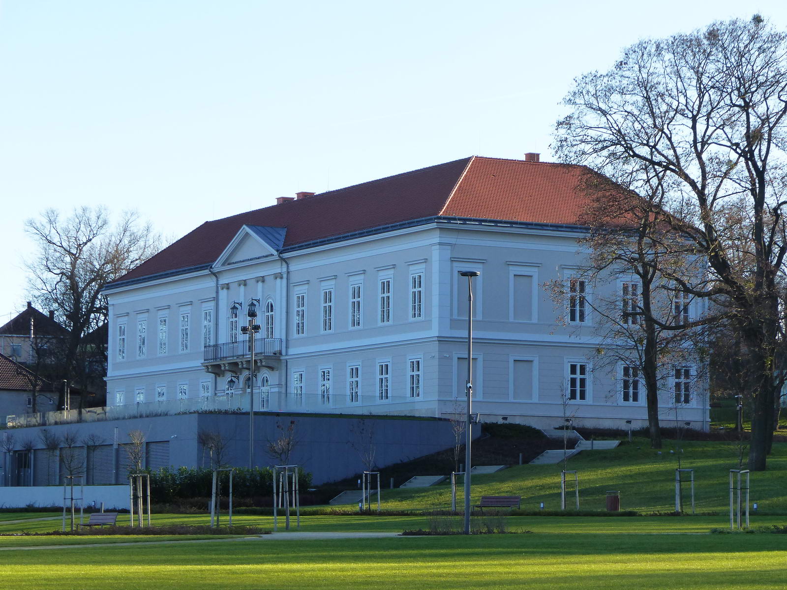 A Hochburg-Lamberg kastély az előtte épült, félig a földbe süllyesztett konferenciateremmel, ami teljesen elrontja a klasszicista kastély összhatását.