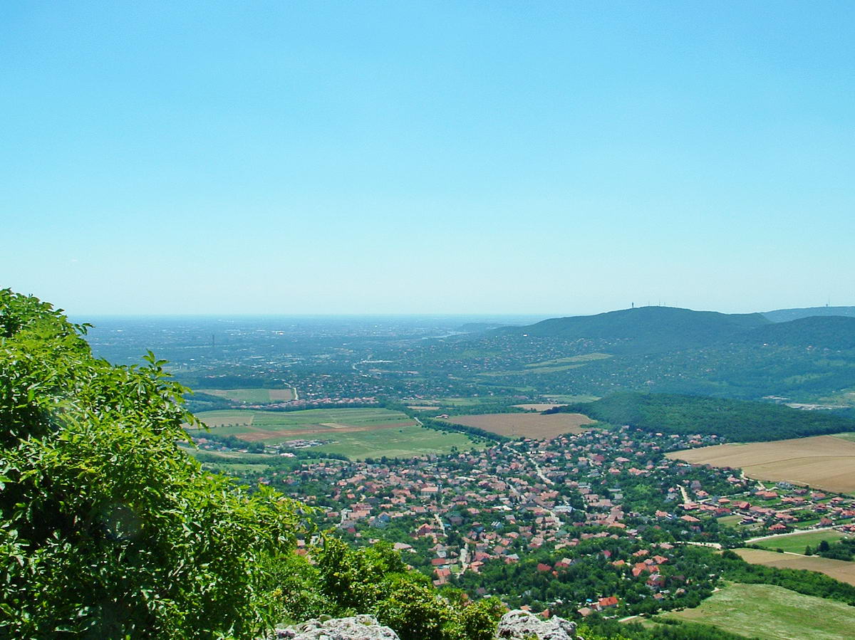 Kilátás a Nagy-Kevély csúcsáról dél felé. Alattunk terül el Pilisborosjenő, távolabb Budapest fekszik a síkon. A háttérben jobbra a Hármashatár-hegy áll.