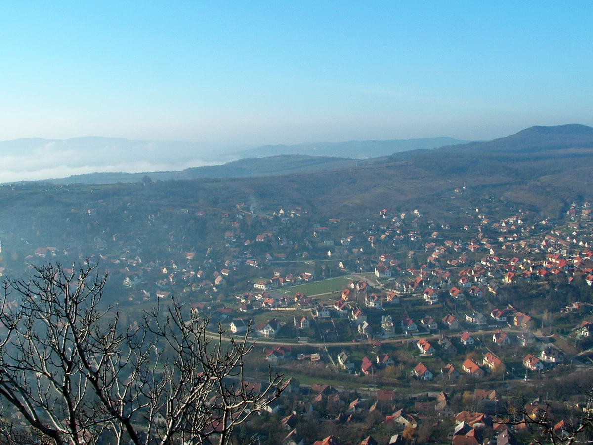 Kilátás Csobánkára és mögötte a széles Csobánkai-nyeregre. A távolban a Solymári-völgyet köd üli meg.