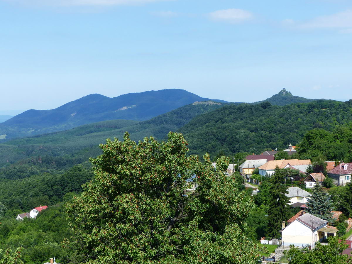 Kilátás Rónafalu legmagasabban fekvő házaira, a távolabbi Salgó várára és a Karancs kétpúpú hátára