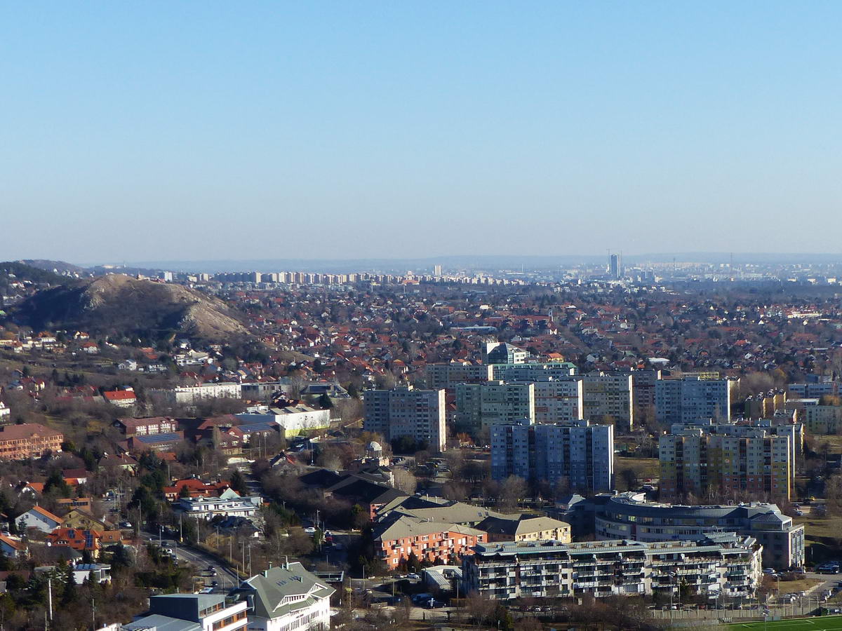 A távoli Gazdagréti lakótelep látképe a Törökugrató sziklás csúcsáról