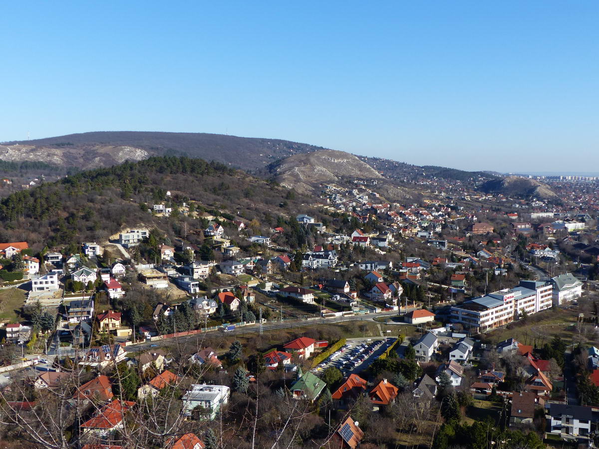Kilátás Budaörsre és a kopár dombokra a Törökugratóról. Balról jobbra haladva a sorrend Út-hegy, Odvas-hegy, Kő-hegy. A háttérben balra a sziklás Farkas-hegy és az erdős a Budaörsi-hegy (Frank-hegy) áll.