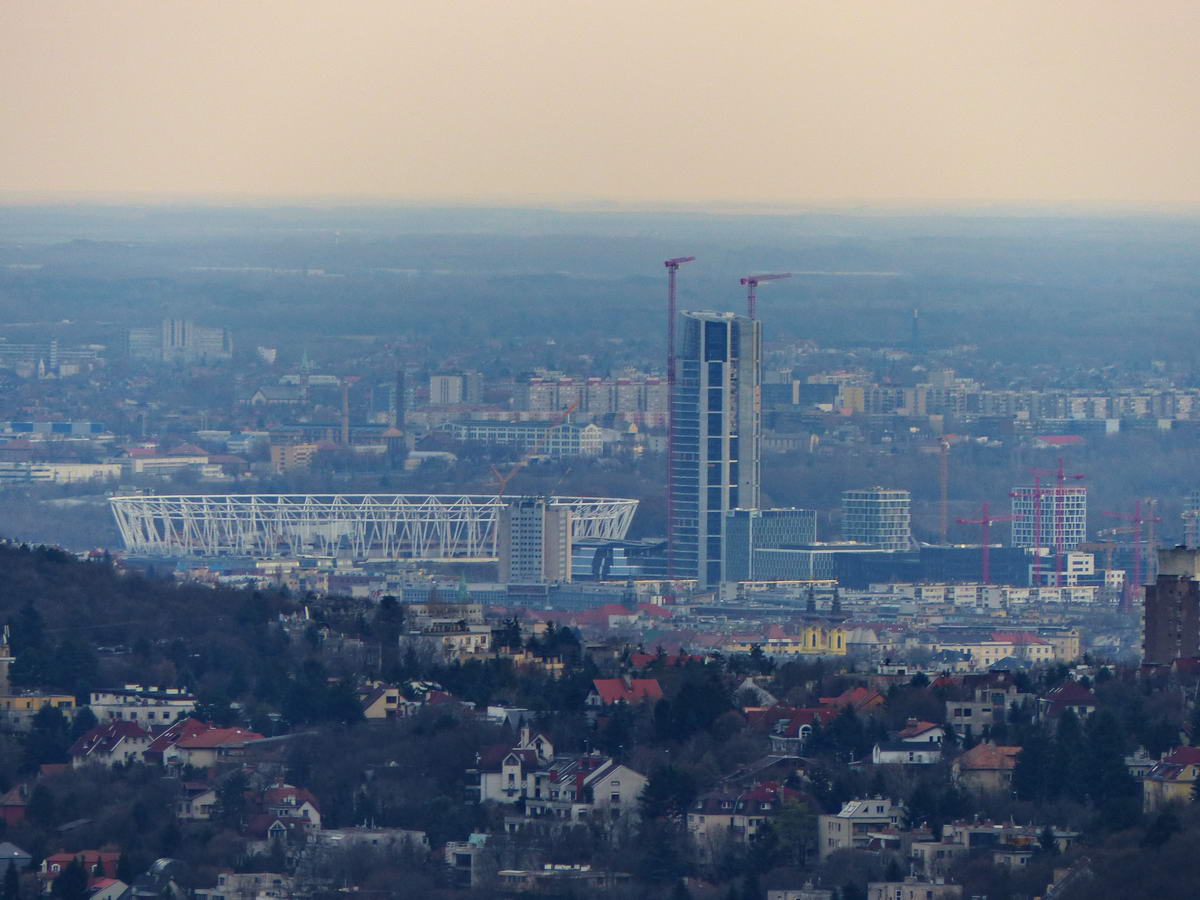 Délkelet felé egymás mögött látható a fénykép készítésekor még épülő MOL Campus felhőkarcolója és az Atlétikai Stadion