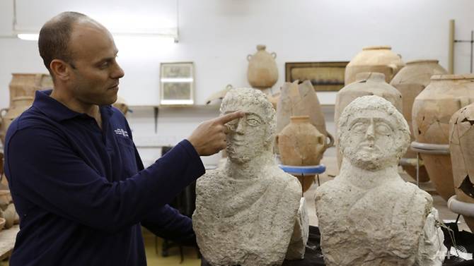 israeli-archaeologist-eitan-klein-of-the-israel-antiquities-authority-shows-off-two-late-roman-busts-unearthed-near-the-ancient-city-of-beit-shean-following-a-chance-find-by-a-woman-walker-1546174345960-2.jpg