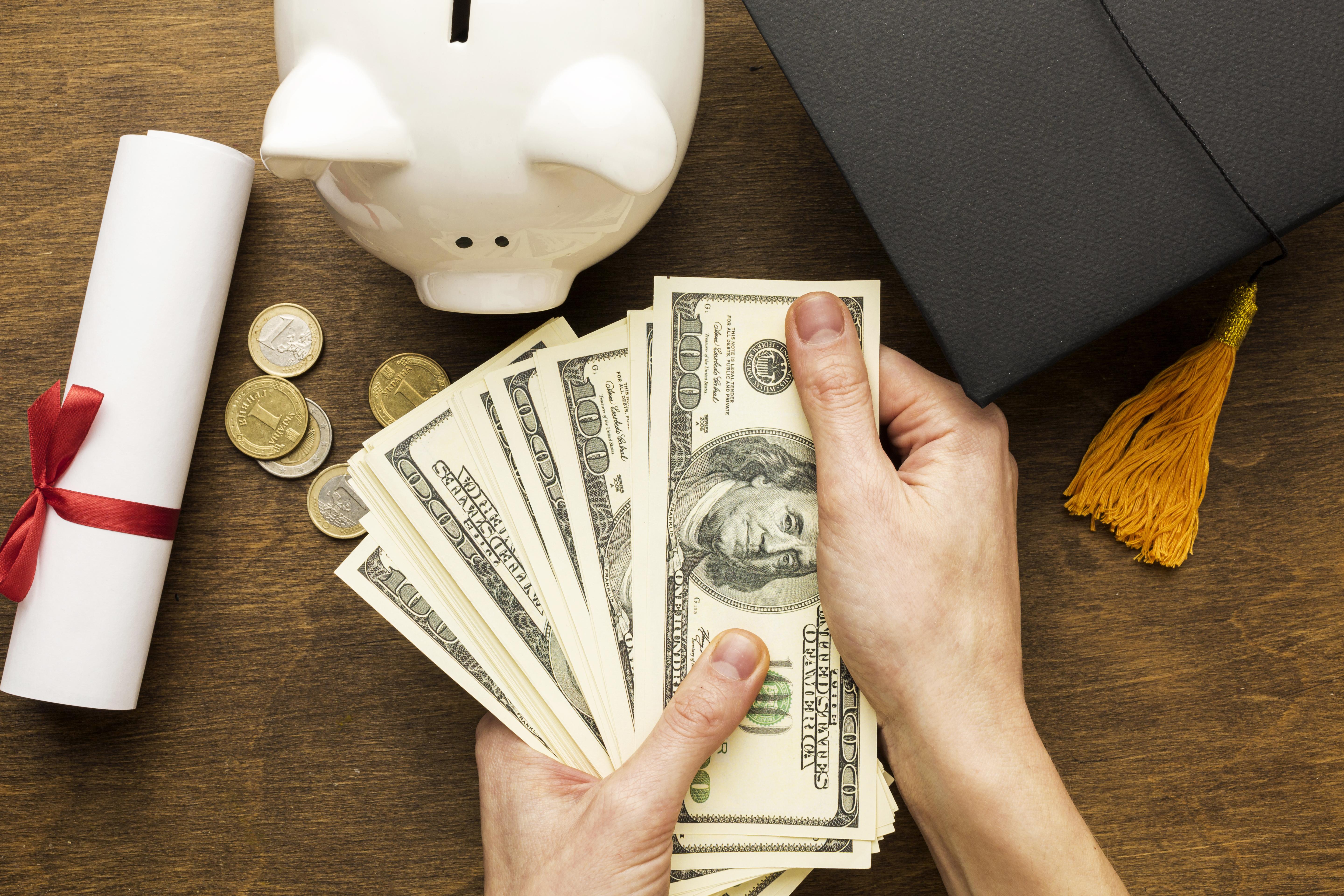 flat-lay-piggy-bank-with-academic-cap-banknotes.jpg