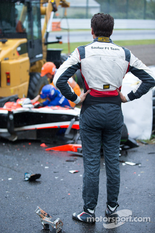 f1-japanese-gp-2014-adrian-sutil-sauber-f1-team-looks-on-as-the-safety-team-at-work-after.jpg