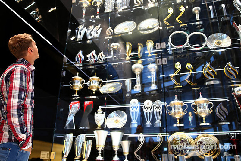 f1-sebastian-vettel-visits-red-bull-racing-factory-2014-sebastian-vettel-looks-at-trophies.jpg