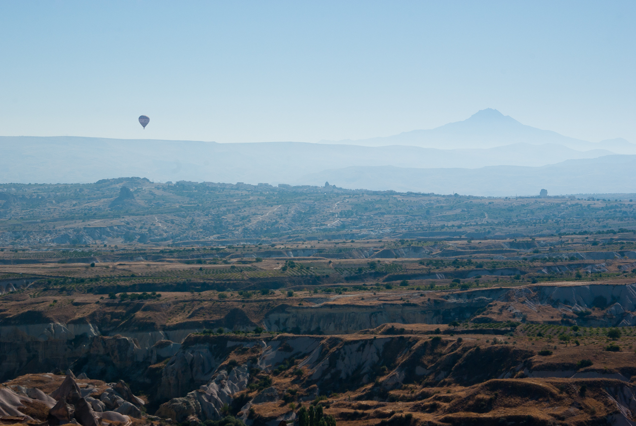 Kilátás a völgyekre Üçhişar-ból. Háttérben az Erciyes és egy elkésett balon.