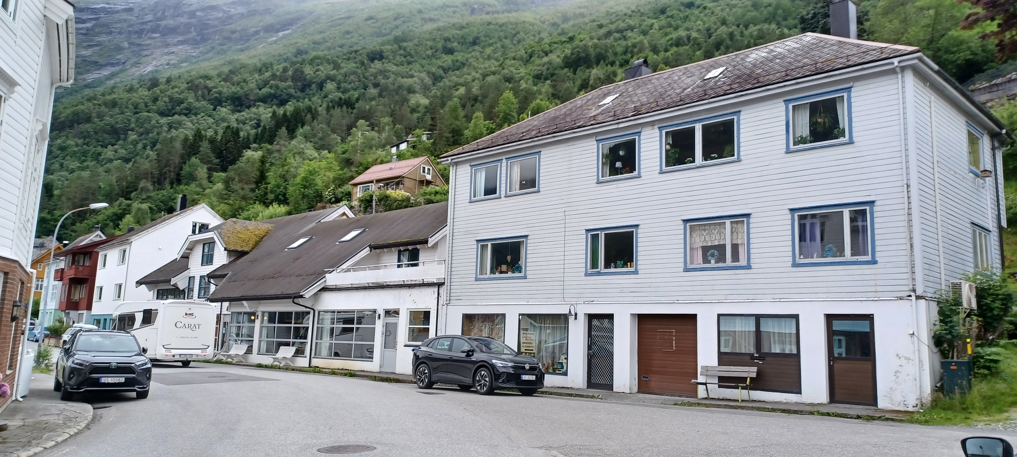 Tipikus norvég utcakép. Sötét autók, faházak, hol függönyös, hogy függönytelen ablakok, kacatokkal ékesítve