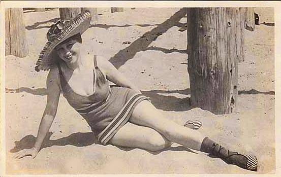 arcade-card-pin-up-woman-on-beach-with-sombrero-leaning-on-one-arm-1920s.jpg