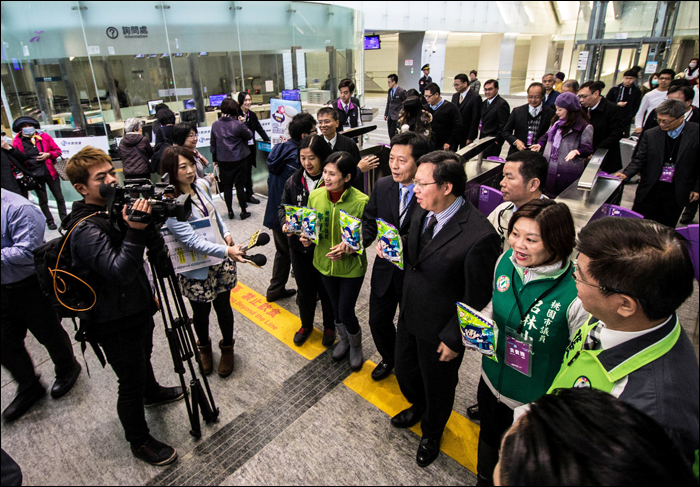A Taoyuan Metro hivatalos megnyitójáról természetesen nem maradhattak el a fontos emberek hordái sem: a képen a zöld kabátos, DPP-s politikusok között öltönyben Taoyuan polgármestere Cheng Wen-can (鄭文燦, szemüveges, hozzánk közelebbi) és a Taoyuan Aerotropolis Co. korábbi vezérigazgatója, Cheng Pao-qing (鄭寶清) bújik meg. A nyitott szájjal pózoló Lu Lin-xiaofengtől (吕林小風), a Taoyuan városi közgyűlés tagjától ezúton is elnézést kérek az előnytelen fotóért.