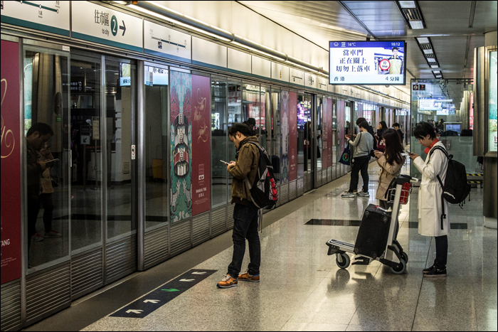 Népek várakoznak a következő Airport Express járatra a hongkongi repülőtér 2-es termináljánál.