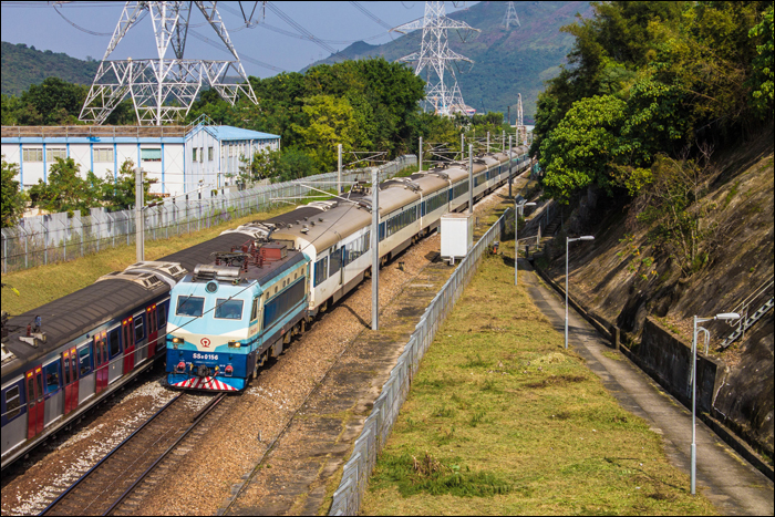 China Railways SS8-as sorozatú villamos mozdony vontatta KTT halad Tai Po közelében.