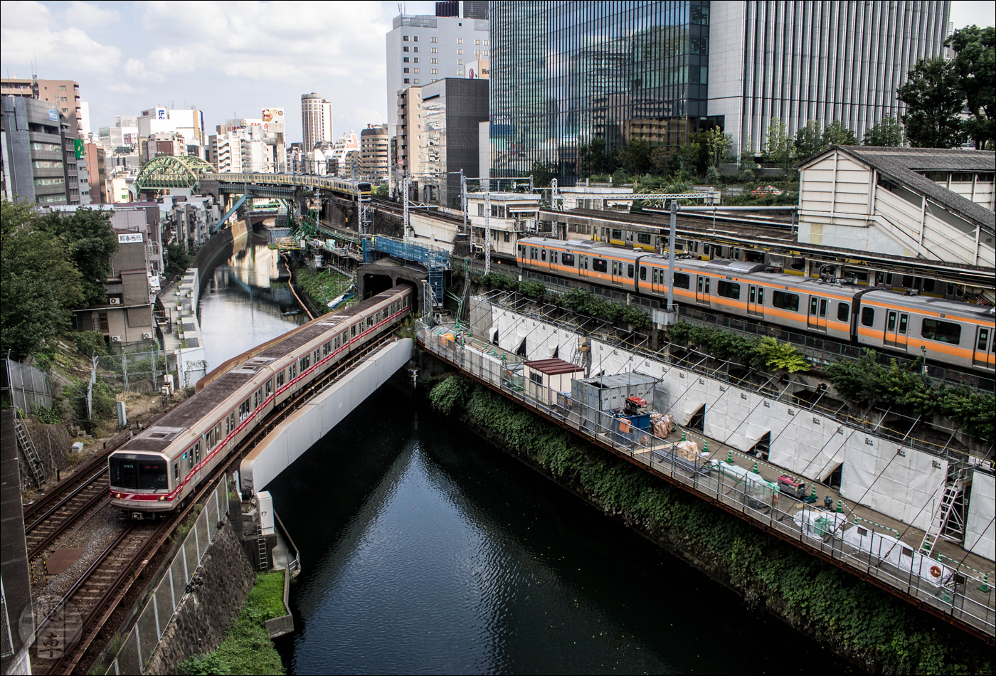 Nemcsak Tokyo, hanem valószínűleg egész Japán egyik legikonikusabb vasúti csomópontja Ochanomizu állomás közelében, a Kanda-folyó felett átívelő hídról nézve. Itt JR részéről a Chuo és Sobu vonalak, Tokyo Metro részéről pedig a Marunouchi vonal keresztezik egymást.