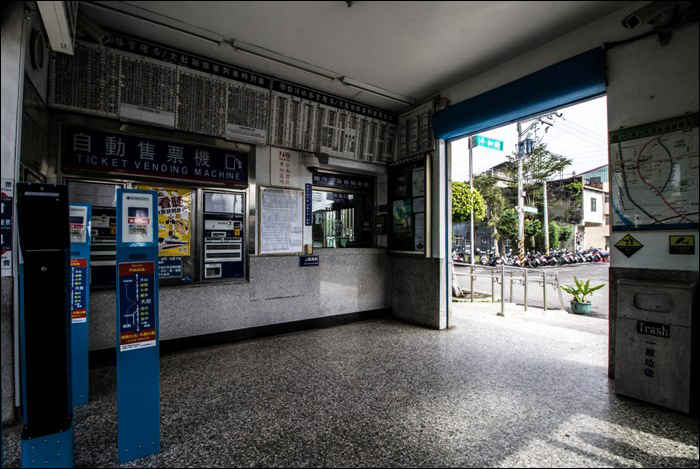 A korábban már említett Longjing megálló váróterme, jegypénztárral és nyomógombos automatával.