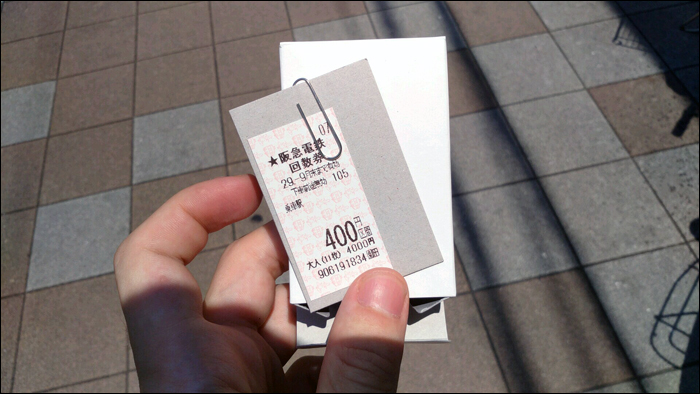 A maszek jegyárusok, jegyautomaták által értékesített menetjegyek ilyen formában, kis dobozban, kartonlapra erősítve érkeznek. A képen jól látható, hogy a 11 darabból álló, kedvezményes tömb értéke 4000 yen, illetve maga a jegy is 400 yenes utazást tesz lehetővé, azonban a spéci automatából megváltva csak 390 yent kellett fizetnem. A dobozt, a kartonpapírt és a gemkapcsot a közvetlenül az automata mellé kihelyezett gyűjtőbe lehet (és illik) visszahelyezni. (A képre kattintva az nagyobb méretben is megtekinthető!)