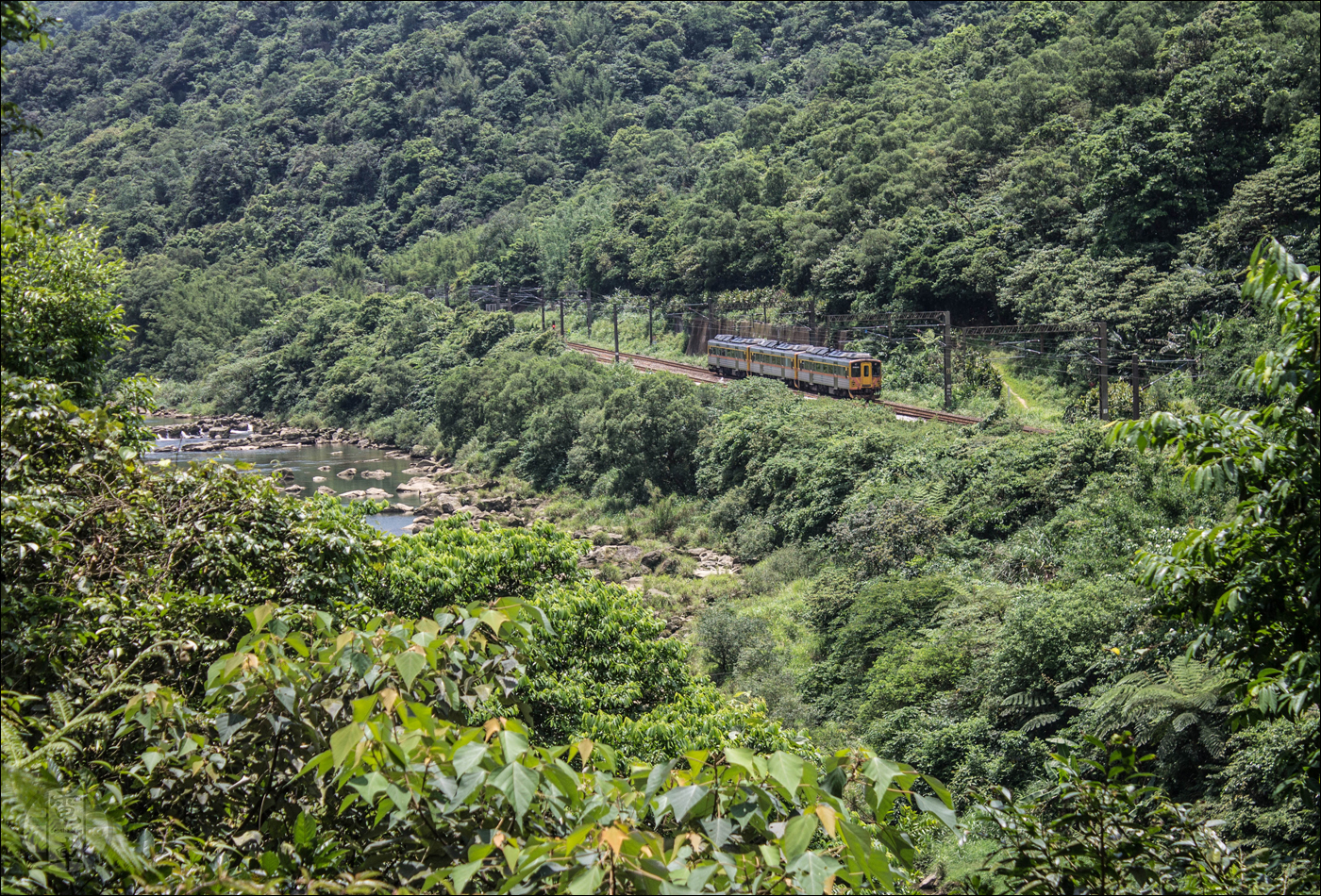 TRA DR1000-es sorozatú motorkocsi (x3) halad a villamosított fővonalon Sandiaoling és Houtong közötti szakaszán Badouzi felé.