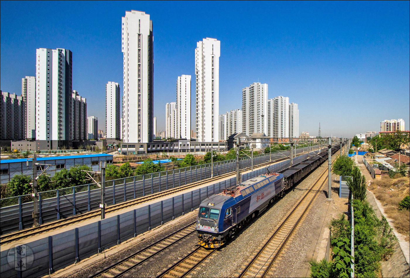 China Railway HXD3B halad tehervonatával Langfang állomás közelében. Az 500 tagú HXD3B sorozat a Bombardier és a CNR Dalian közreműködésével került a kínai vaspályákra, így a járművek az LKAB IORE és a Bombadier Traxx 2 mechanikai és villamos tulajdonságait is magukon hordozzák.
